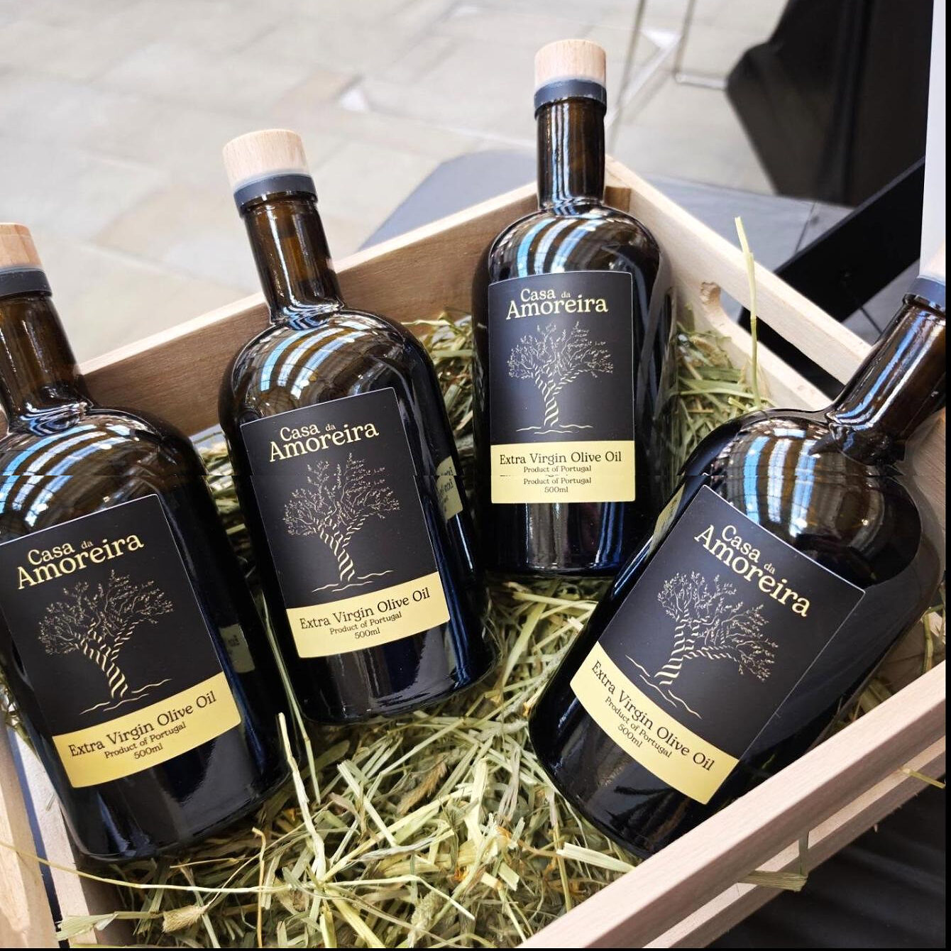 Four bottles packed in straw in a wooden crate